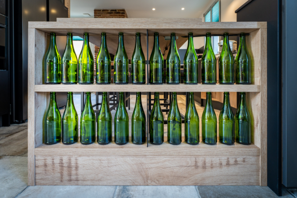 Un étagère sur mesure accueille des bouteilles à cidre de Bayeux, pour la touche déco.